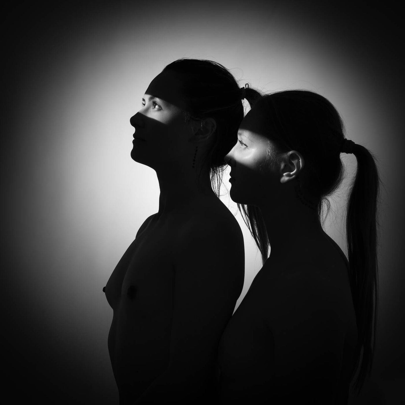 Dois perfis de mulher em contraluz, um atrás do outro